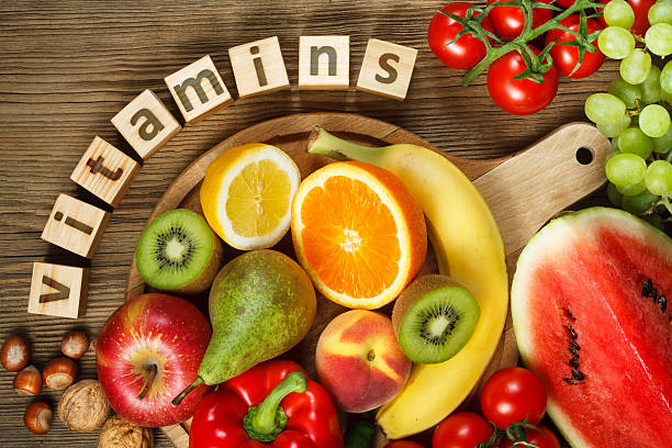 Vitamins in fruits and vegetables Vitamins in fruits and vegetables. Natural products rich in vitamins as oranges, lemons, red pepper, kiwi, tomatoes, bananas, pears, apples, walnuts, watermelon, hazelnuts, peach and green grape vitamin stock pictures, royalty-free photos & images
