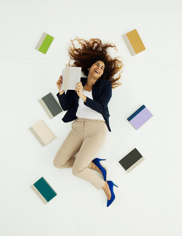 Above view of businesswoman lying with bookshttp://www.twodozendesign.info/i/1.png