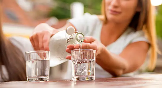 Pouring water in glass, Refreshments at coffee bar, Water pouring from bottle into the glass