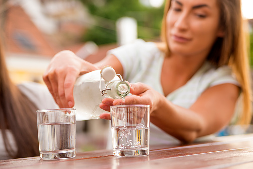 Pouring water in glass, Refreshments at coffee bar, Water pouring from bottle into the glass