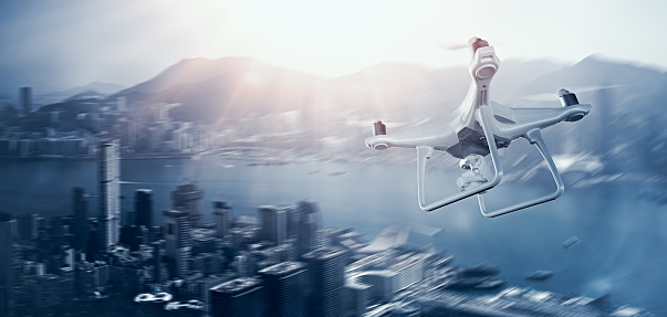 Photo White Matte Generic Design Remote Control Air Drone with action camera Flying Sky under City. Modern Megapolis Background. Wide, side angle view. Motion blur Effect. 3D rendering