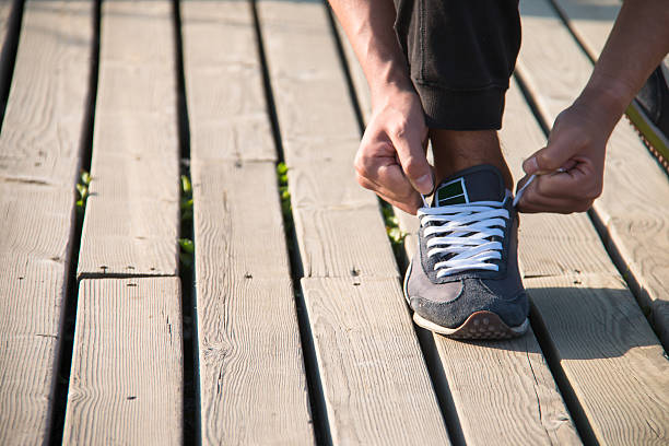 istock close up man runner tying shoelaces 538181552