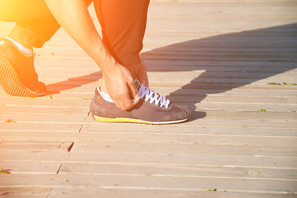 istock close up man runner tying shoelaces 538181662
