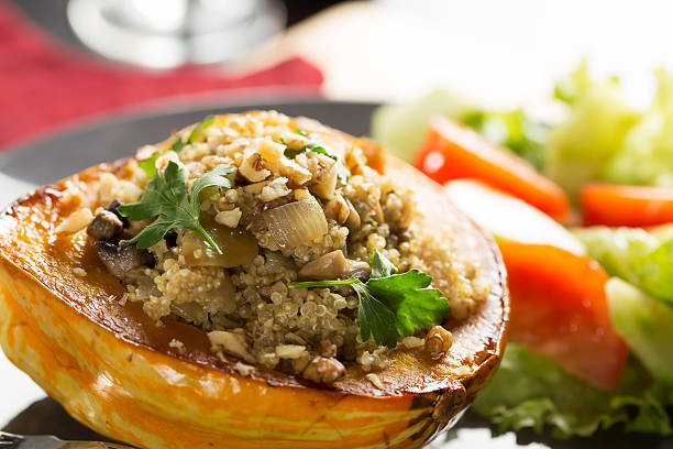 Stuffed Squash Meal Winter Squash stuffed with quinoa, mushrooms and onions. acorn squash stock pictures, royalty-free photos & images