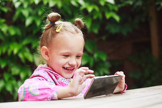 istock toddler girl using a smart phone 538183232