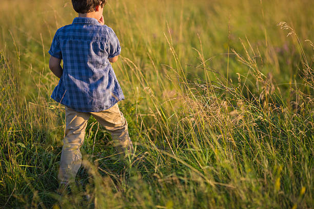 Little boy in blue shirt goes on a field