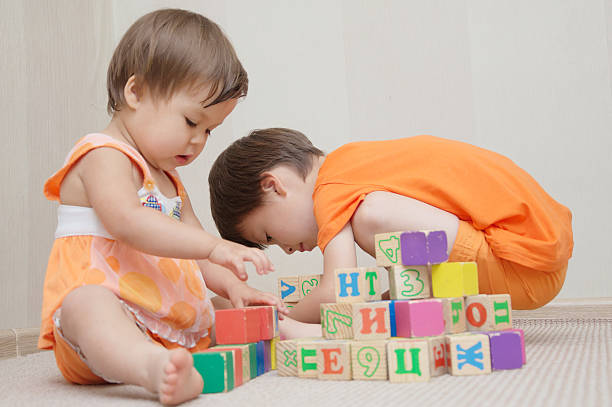 istock Brother and sister playing with toy cubes 538187336