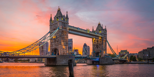 Dramatic sunset skies above the iconic span of Tower Bridge framing the futuristic skyscrapers of the Square Mile financial district above the slow moving waters of the River Thames in the heart of London, Britain's vibrant capital city. ProPhoto RGB profile for maximum color fidelity and gamut.