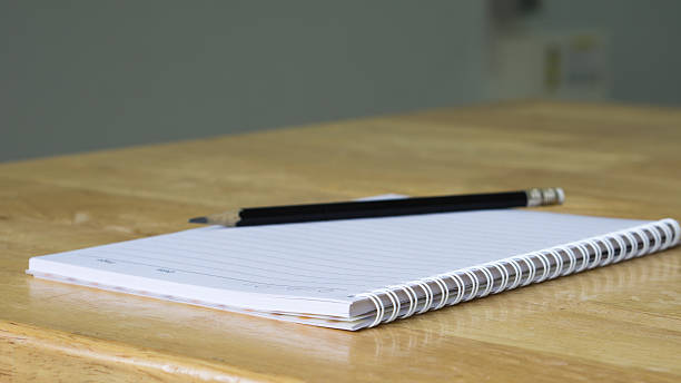 istock Top View Pencil with paper and book on wooden table 538193684