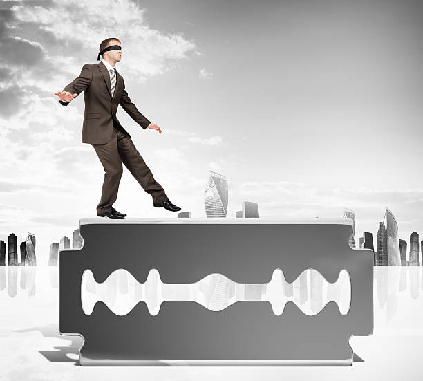 istock Businessman walking carefully on old razor blade 538196470