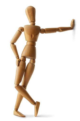 A vertical shot of a wooden human body figure isolated on gray background
