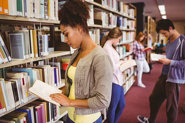 istock Students reading book against bookshelves 538202367