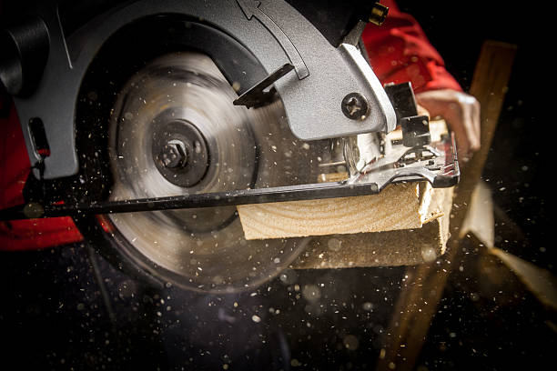 Carpenter with Circular Saw Close-up of carpenter cutting a wooden plank sawhorse stock pictures, royalty-free photos & images