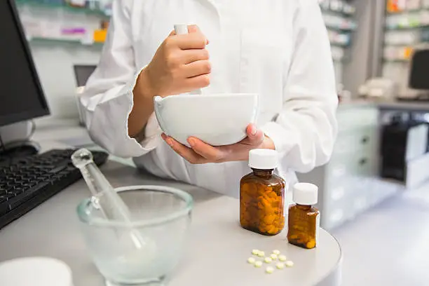 Photo of Junior pharmacist mixing a medicine