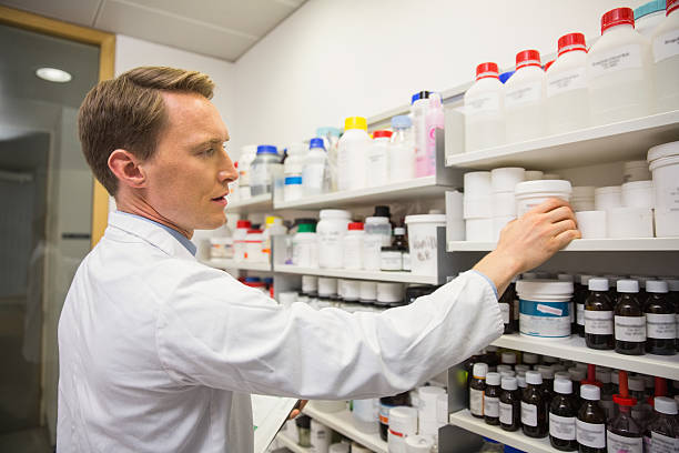 istock Handsome pharmacist taking medicine from shelf 538204421