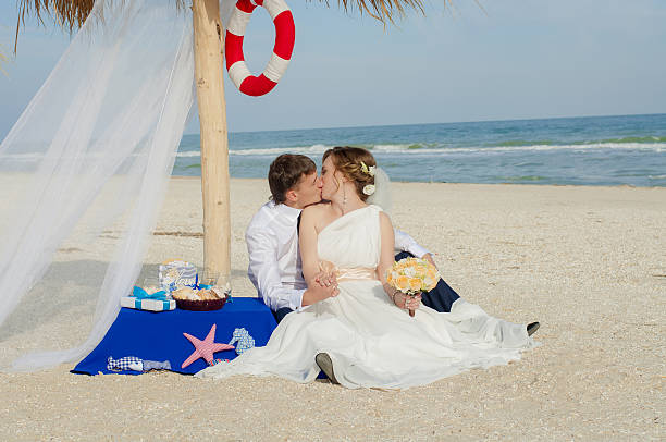 Young bride and groom on the beach stock photo