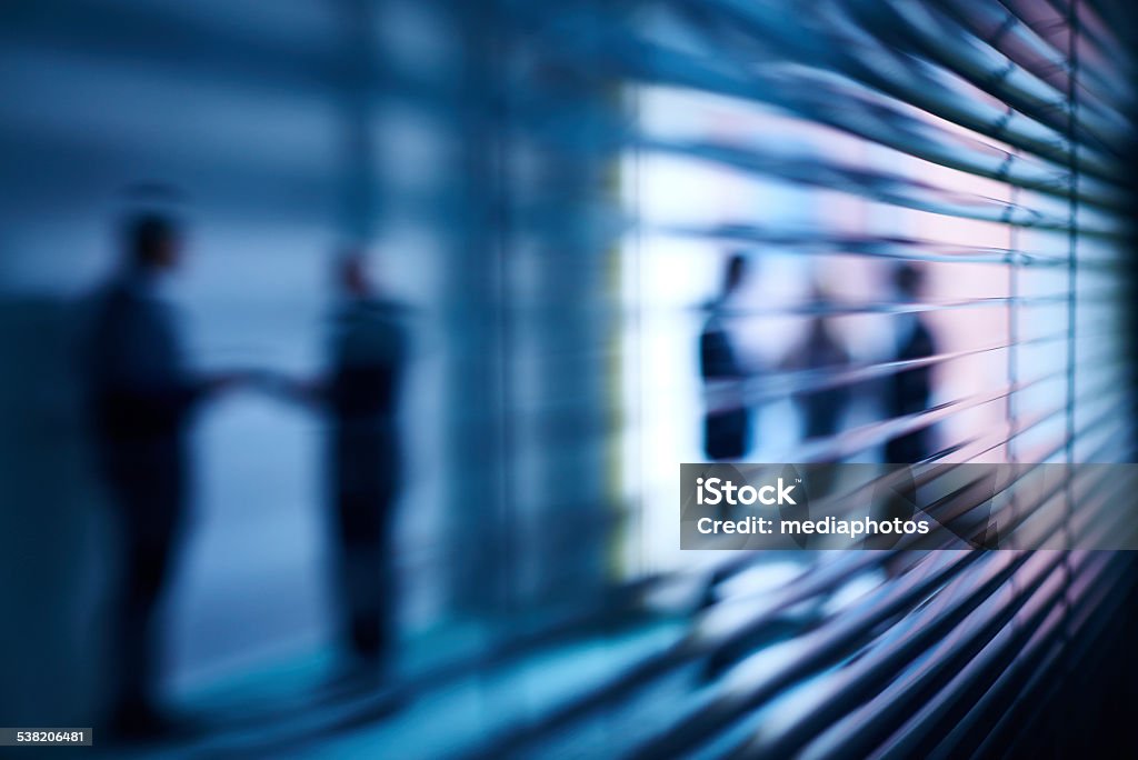 Interaction behind blinds Silhouettes of business people interacting behind open blinds Abstract Stock Photo