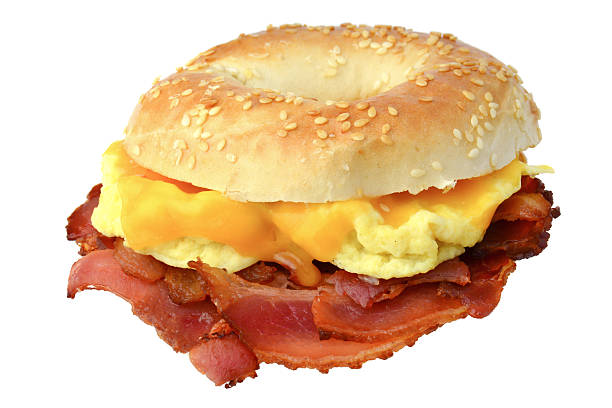 bagel con pancetta, uova strapazzate e formaggio cheddar - sandwich eggs bacon breakfast foto e immagini stock