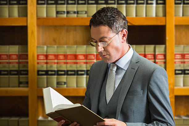 istock Lawyer reading book in the law library 538235125