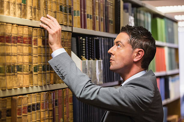 istock Lawyer picking book in the law library 538235653
