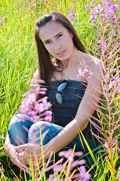 istock Beautiful brunette female sitting in field 538259457