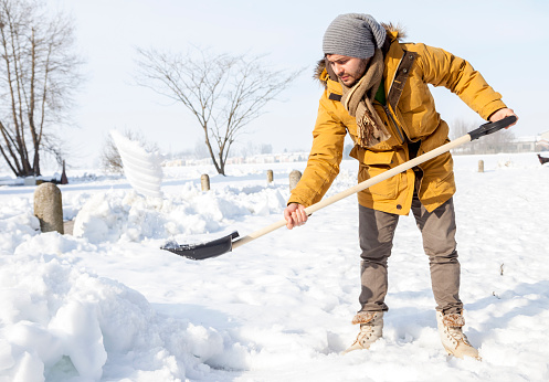 young man shoveling snow in the country