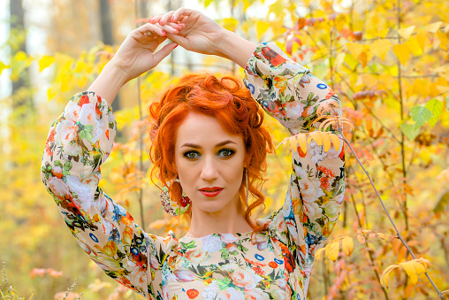beautiful readhead woman in the autumn forest