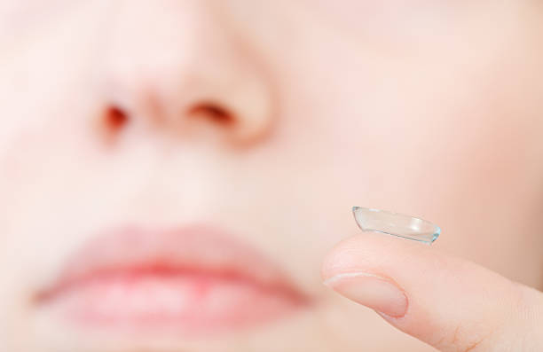 istock corrective lens on finger near female face 538279807
