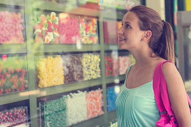 Woman admireing different candys through shop window