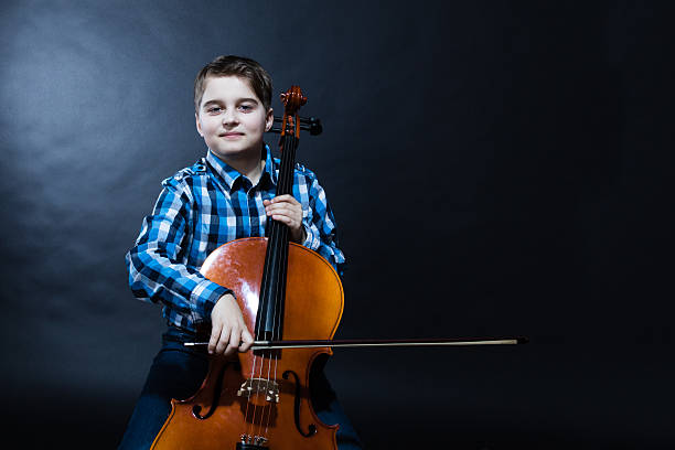 young Cellist playing classical music on cello stock photo