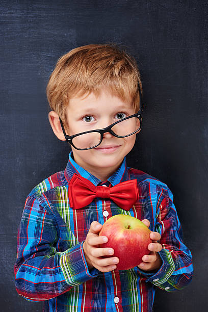 istock Mixed-up ginger primary school age boy holding red apple 538300641