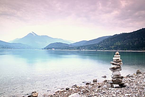 istock Balanced stone pyramide on shore, blue water of mountain lake. 538322548