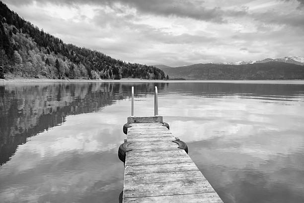 istock Empty wooden mole on  blue Alps lake, wharf for boats 538323470