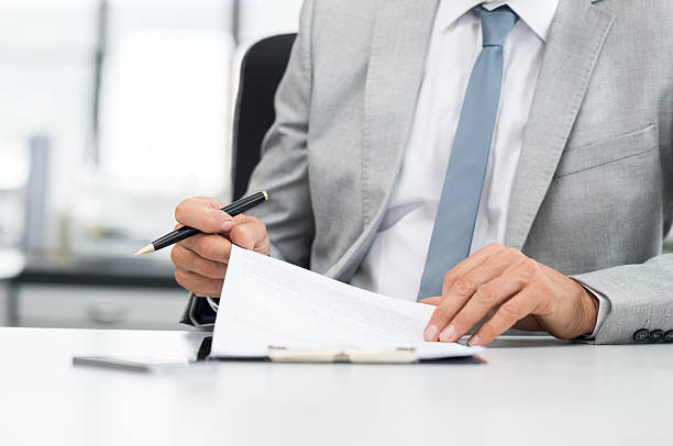 Businessman signing contract Senior analyst managing business accounts. Close up of a senior businessman hands checking final report before submission. Close up of hands of leadership signing business contract. cfo stock pictures, royalty-free photos & images