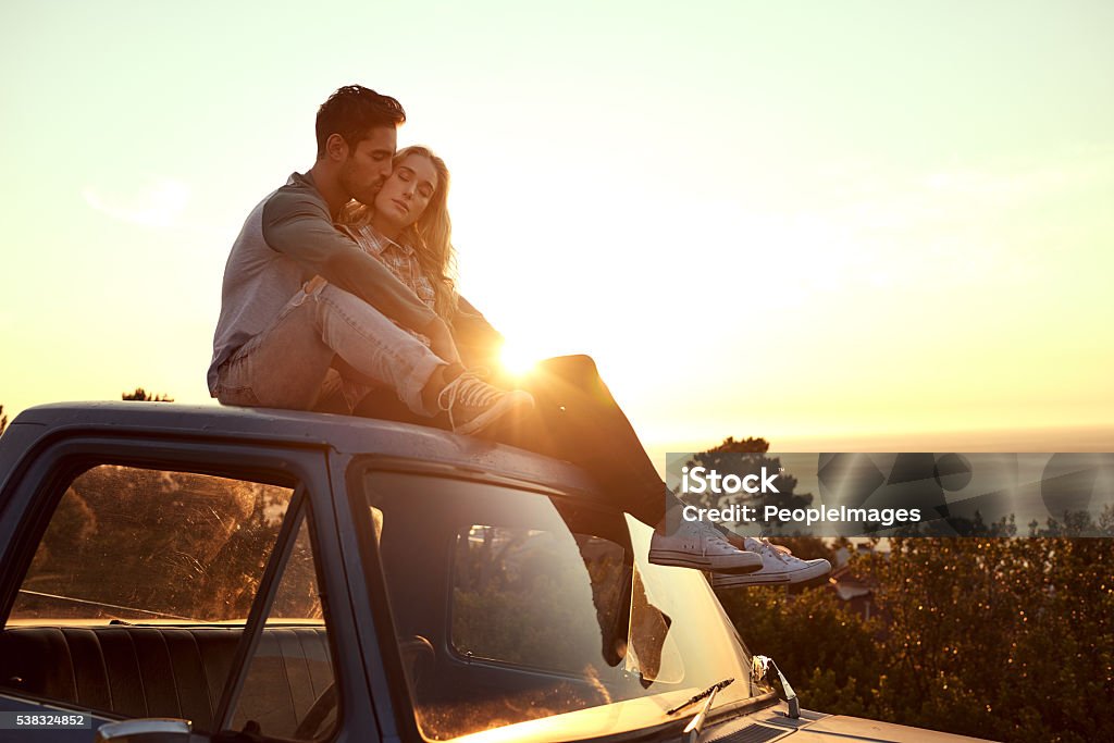 They found the perfect spot for some loving Shot of an affectionate young couple on a roadtrip 20-29 Years Stock Photo