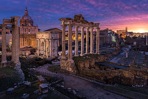 Crack of dawn Today i had the opportunity to shoot the ancient part of Rome, known as the Roman Forum. i had a walk around the city since it took me a while to get there, through the early morning and i was almost hopeless about the sky, but yet when i approached the old city some colors begun to pop in the clouds. I rushed a little to arrive to the location i intended to shoot and started to look for the perfect angle, the colors in the sky were just amazing. and i was super excited to have the opportunity to at least see this natural phenomenon and even more capture that with my camera. It was simply stunning ..I did 3 shots for this one (bracketed -1,0,+1) and than blended basically the 0 and +1 exposure since thats all i needed to achieve the perfect balance of light, the shot was fantastic from camera and very minor changes have been done in post processing, like some color correction in the foreground and also removing the tint from the sky reflection on the pavement..Hope you enjoy roman empire stock pictures, royalty-free photos & images
