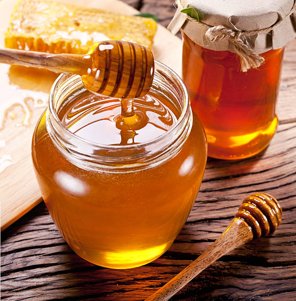 istock Honey dripping from wooden spoon. 538327037