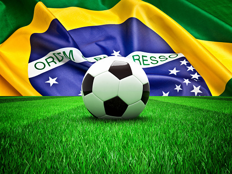 soccer ball on grass and brazil flag