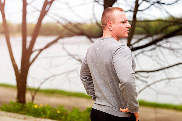 Young man resting after runing. looking on river. stock photo