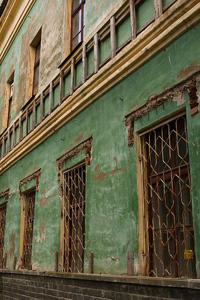 old green shabby wall of an abandoned building - brunt imagens e fotografias de stock