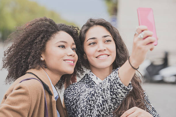 istock Two female friend smiling and taking selfie 538334886