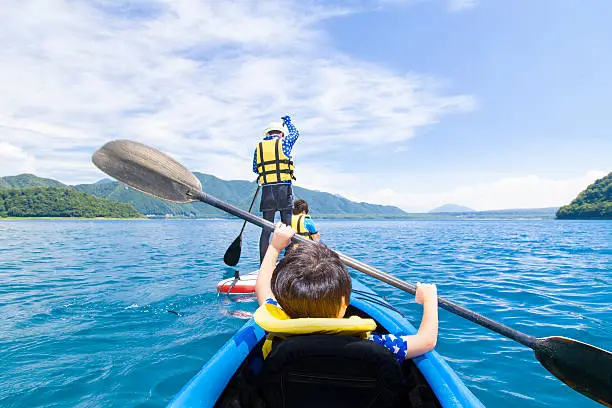 Asian mother and her son on the canoe and Stand up paddle board.