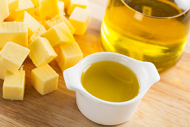 Butter or Olive Oil Olive oil in small glass container with bottle of oil and cubes of butter butter stock pictures, royalty-free photos & images