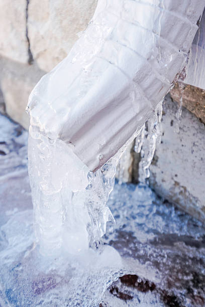 downspout z wodą obrócona do lodu podczas śnieżyca - melting ice icicle leaking zdjęcia i obrazy z banku zdjęć