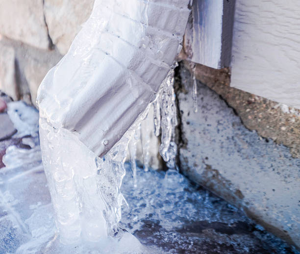 downspout водой положилась на льду в «снежная буря» - melting ice icicle leaking стоковые фото и изображения