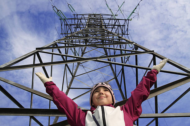 criança segura as mãos perto da torre de transmissão de alta tensão - nuclear power station nuclear energy child nuclear reactor - fotografias e filmes do acervo