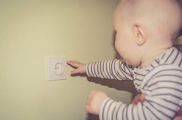 istock Dangerous baby sticking fingers into electrical outlet 538342760