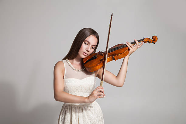 istock Beautiful young woman playing violin 538345644