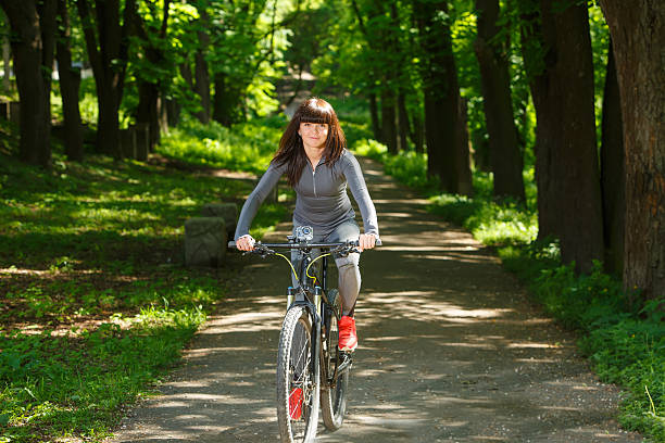 istock cyclist woman riding a bicycle in park 538346056
