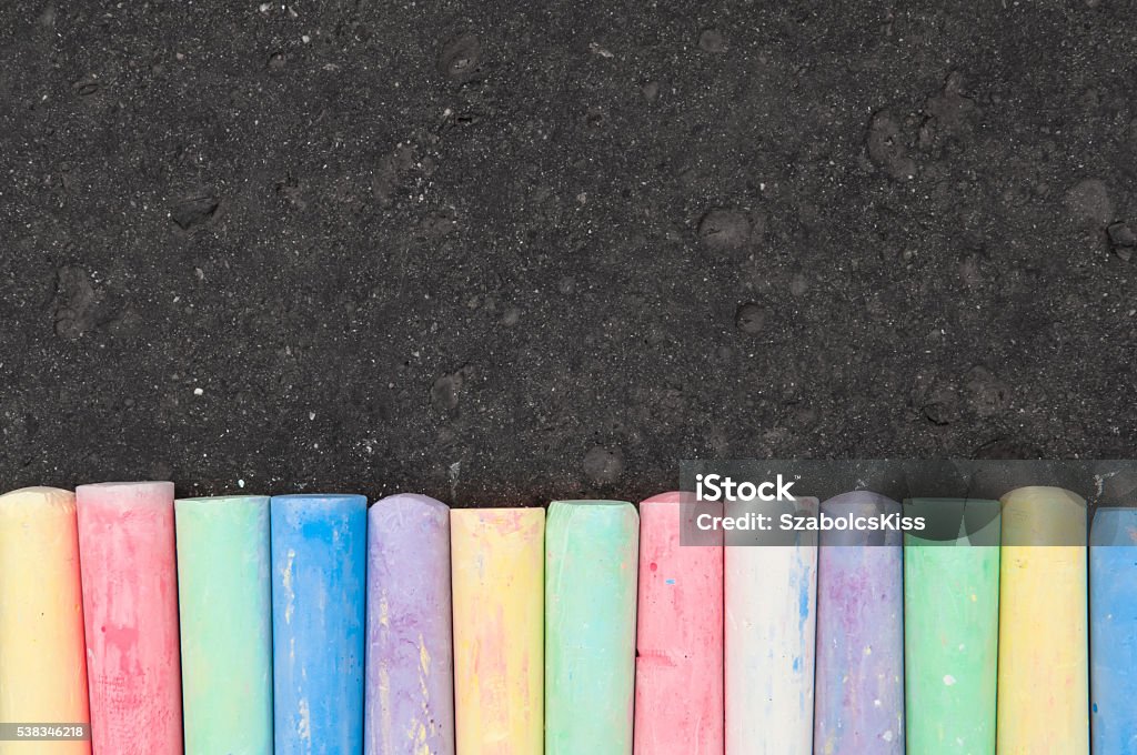 Colorful pastel sidewalk chalk on dark asphalt background. Colorful pastel sidewalk chalk on dark asphalt background. Top view Chalk Drawing Stock Photo